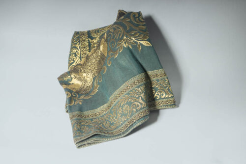 Teal & gold tapestry material waiting to be a medieval collar